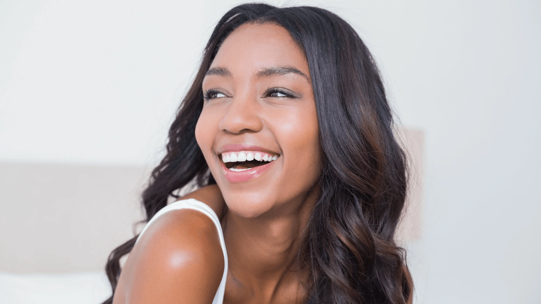 A woman smiling with long hair after Microneedling Treatments in Meridian, ID | Oasis MedSpa & IV Bar